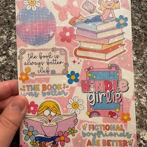 May include: A pink and white sticker sheet featuring illustrations and text. Designs include a disco ball, flowers, a girl reading, and the phrases "the book is always better club", "the book was better", "Kindle Girlie", and "fictional boyfriends are better".