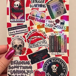 May include: A rectangular sticker sheet featuring a red and white checkered background with various dark romance book-themed designs, including skulls, hearts, books, and text such as "Trigger Warning," "Morally Grey Men," and "Dark Romance Book Club."