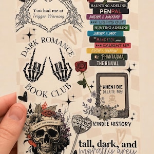 May include: A sticker sheet featuring dark romance book themes, including skeleton hands forming hearts and rock signs, a stack of book titles, a skull with flowers, and text reading "You had me at Trigger Warning," "Dark Romance Book Club," and "When I die delete my Kindle history."