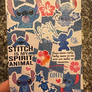May include: A blue and white checkered background with a variety of stickers featuring the character Stitch from the Disney movie Lilo & Stitch. The stickers include Stitch holding a coffee cup, Stitch with a flower, Stitch with the text "Stitch is my spirit animal", and Stitch with the text "Ohana means family. Family means no one gets left behind or forgotten."