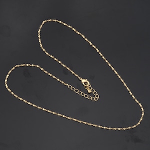 May include: A gold chain necklace with a delicate, twisted design. The chain is approximately 18 inches long and has a lobster claw clasp.