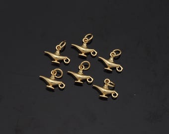 May include: Seven gold-coloured genie lamp charms. The charms are small and detailed, with a loop at the top for attaching to a necklace or bracelet.