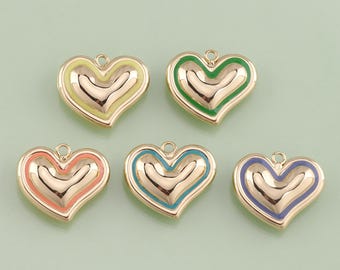 May include: Five heart-shaped pendants with gold-colored metal and colorful enamel accents. Each heart has a different color: yellow, green, coral, teal, and purple. The pendants have a loop at the top for attaching to a chain or other jewelry.