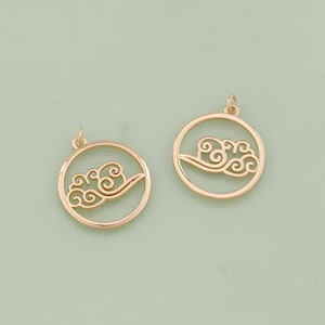 May include: Two gold-tone metal charms in the shape of a circle with a cutout design of a cloud.