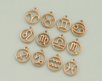 May include: Gold-toned metal charms featuring the twelve zodiac signs. Each charm is a circle with a cutout of the zodiac symbol.
