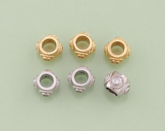 May include: Six decorative beads in gold and silver tones. The gold beads have a textured design, while the silver beads have a smooth finish and a central clear stone. The beads are round with a hole through the center, suitable for jewelry making.