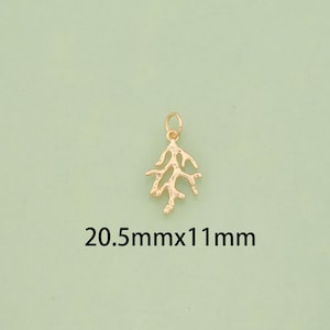 K&ouml;nnte beinhalten: Ein goldfarbener Anh&auml;nger in Form eines Korallenastes. Der Anh&auml;nger misst 20,5 mm x 11 mm. Der Anh&auml;nger hat oben eine kleine Schlaufe zum Befestigen an einer Halskette oder einem Armband. Der Hintergrund ist hellgr&uuml;n.