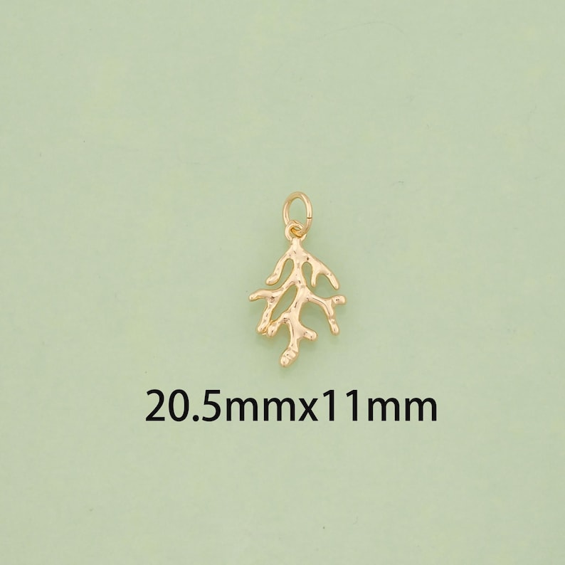 K&ouml;nnte beinhalten: Ein goldfarbener Anh&auml;nger in Form eines Korallenastes. Der Anh&auml;nger misst 20,5 mm x 11 mm. Der Anh&auml;nger hat oben eine kleine Schlaufe zum Befestigen an einer Halskette oder einem Armband. Der Hintergrund ist hellgr&uuml;n.