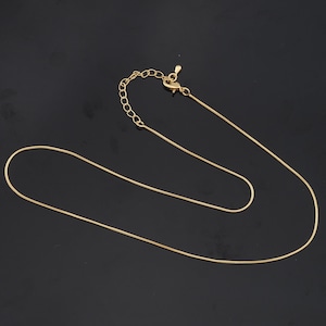 May include: A gold chain necklace with a lobster clasp closure.