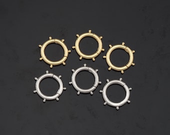 May include: Six small, round, metal hoops with a decorative bead design. Three hoops are gold and three are silver.