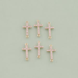 May include: Six gold-tone cross charms with clear crystal embellishments. Each charm has two jump rings for attaching to jewelry.
