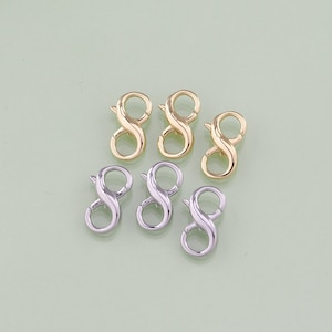 May include: Six gold and silver infinity clasps, also known as lobster clasps, for jewelry making. These clasps are perfect for necklaces, bracelets, and other jewelry projects.