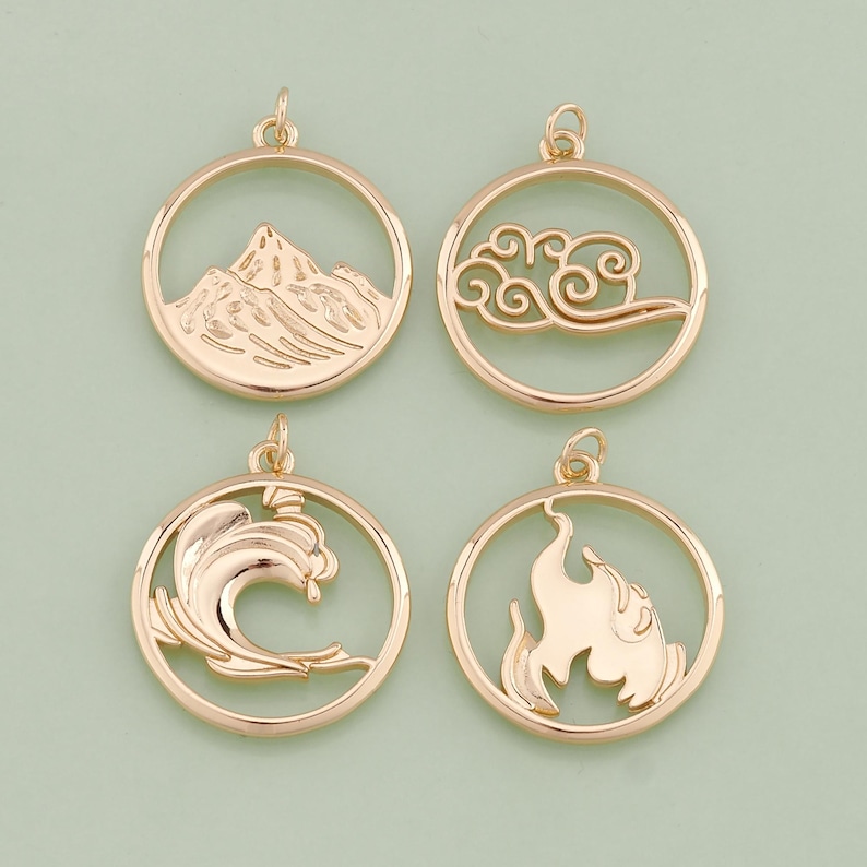 May include: Four gold-colored metal charms with different designs. The charms are round and have a hole at the top for attaching to a necklace or bracelet. The designs are a mountain, a cloud, a wave, and a flame.
