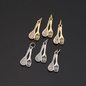 May include: Six gold and silver spoon and fork charms with clear rhinestones. The charms are perfect for adding a touch of sparkle to jewelry projects.