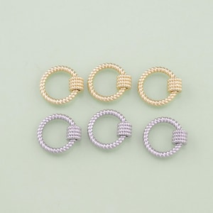 May include: Six gold and silver hoop earrings with a twisted rope design and a small cylinder bead in the center.