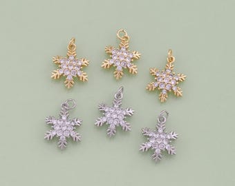 Könnte beinhalten: Sechs silberne und goldene Schneeflocken-Anhänger mit klaren Kristall-Akzenten. Die Anhänger sind perfekt, um Schmuck, Bastelarbeiten und anderen Projekten einen Hauch von Winterzauber zu verleihen.