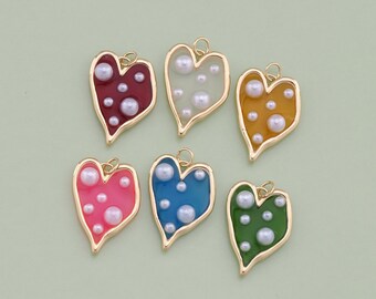 May include: Six gold heart-shaped charms with different colored enamel and white pearl accents.