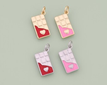 Può includere: Quattro ciondoli a forma di barretta di cioccolato con dettagli a cuore. Due sono dorati con accenti rossi e rosa, e due sono argentati con accenti rossi e rosa. Ogni ciondolo ha un piccolo anello.