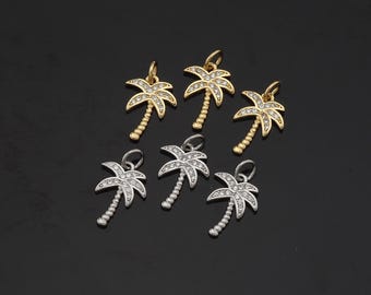 May include: Six palm tree charms with clear rhinestones. Three charms are gold and three are silver.
