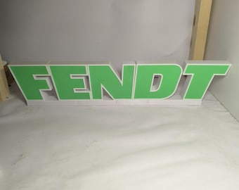 May include: A green Fendt logo made of foam letters. The letters are white with green lettering.