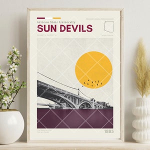 Op de afbeelding: Een minimalistische poster met een kleurenschema in maroon, wit en geel. De poster toont een zwart-wit afbeelding van een brug, een gele zon en de tekst "Arizona State University SUN DEVILS" in maroon en wit. De poster bevat ook een kleine omtrek van de staat Arizona en het jaar "1885".