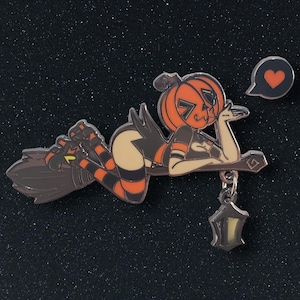 May include: A Halloween-themed enamel pin featuring a pumpkin-headed character reclining on a broom. The character wears a black and orange outfit with striped stockings. A heart-shaped speech bubble and a lantern charm are also included.