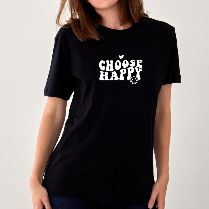 May include: Black t-shirt with a white graphic that says "CHOOSE HAPPY" in a retro font with a small heart and a smiley face.