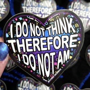 May include: Heart-shaped sticker with the text "I DO NOT THINK THEREFORE I DO NOT AM" in white, outlined in black. The background transitions from blue to purple, with colorful confetti-like shapes.