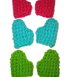 K&ouml;nnte beinhalten: Sechs geh&auml;kelte fingerlose Handschuhe in Herzform in Pink, T&uuml;rkis und Gr&uuml;n.
