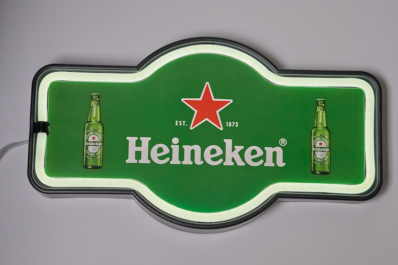 May include: A rectangular Heineken LED sign with rounded edges, featuring a green background, a red star, and the text "EST. 1873" and "Heineken". Two green beer bottles are printed on the left and right sides of the illuminated display.