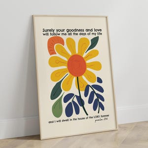 Pode incluir: Um design de arte de parede imprimível com uma flor amarela estilizada com um centro vermelho e folhas verdes e azuis. O texto diz "Certamente a tua bondade e o teu amor me seguirão todos os dias da minha vida e habitarei na casa do SENHOR para sempre Salmo 23:6".