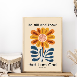 Può includere: Un poster beige con un fiore stilizzato in tonalità arancio, giallo e rosa. Il fiore ha uno stelo e foglie blu. Il testo sul poster recita "Be still and know that I am God, Psalm 46:10".