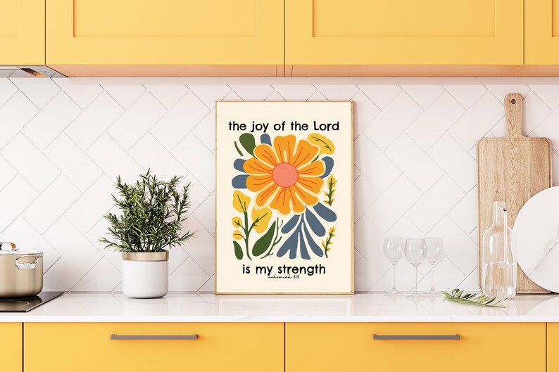 May include: A white poster with a colorful floral design and the text "the joy of the Lord is my strength" in black lettering.
