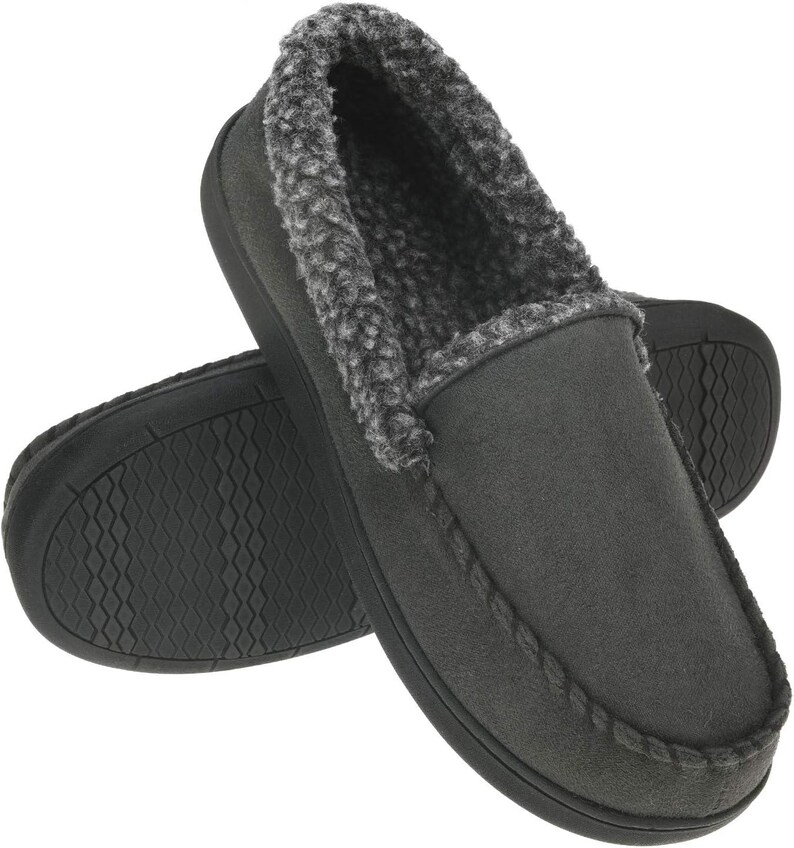 Puede incluir: Un par de zapatillas de estilo mocas&iacute;n de color gris antracita. Las zapatillas tienen un exterior de ante sint&eacute;tico suave y un forro de piel sint&eacute;tica gris afelpada. Las suelas son negras y texturizadas para un mejor agarre. El dise&ntilde;o es sencillo y c&oacute;modo.