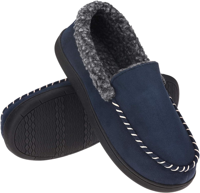 Puede incluir: Zapatillas de color azul marino con aspecto de ante, suela negra y costuras blancas. El interior y el cuello est&aacute;n forrados con piel sint&eacute;tica gris. Estas zapatillas sin cordones est&aacute;n dise&ntilde;adas para la comodidad y el calor.