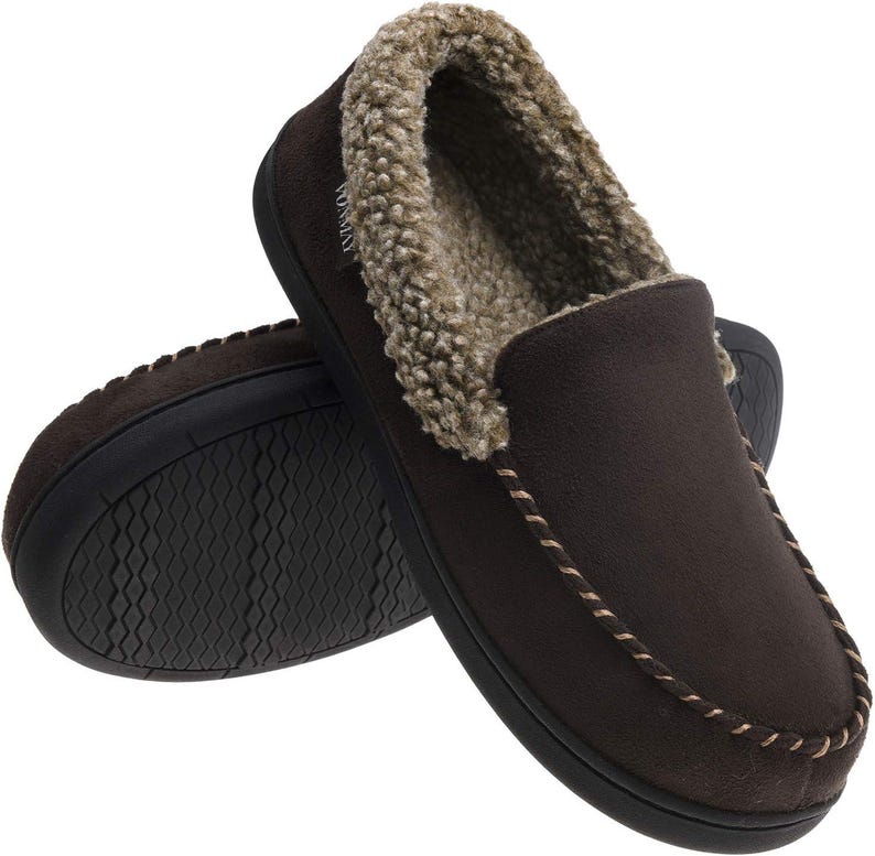 Puede incluir: Zapatillas marrones de imitaci&oacute;n de ante con forro y ribete de suave piel sint&eacute;tica color beige. Las zapatillas tienen un dise&ntilde;o sin cordones con un detalle cosido alrededor de la abertura. Las suelas son negras y texturizadas.