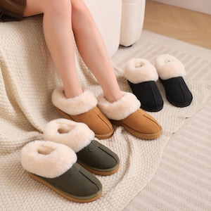May include: Four pairs of fuzzy slippers in brown, green, and black. The slippers have a soft, fluffy lining and a suede-like outer material.