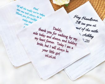 May include: Three white handkerchiefs with embroidered text in various colors. One has blue text that reads "Dad, Of all the walks we've taken..." Another has burgundy text: "Daddy, thank you for walking by my side..." The third has black text: "Hey Handsome, I'll see you at..."