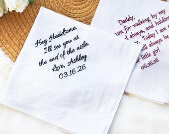 May include: Two white handkerchiefs with embroidered text. One says "Hey Handsome, I'll see you at the end of the aisle. Love, Ashley 03.16.26." The other says "Daddy, you for walking by my... Today I am a... 06.26.26."