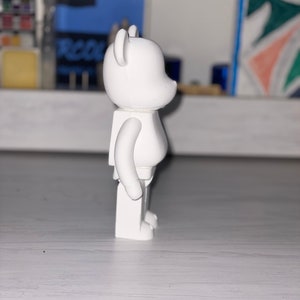 May include: A white bear-shaped figurine with a simple design. The figurine is made of plastic and has a smooth, matte finish.