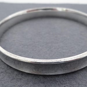 May include: A silver bangle bracelet with a smooth, polished finish.