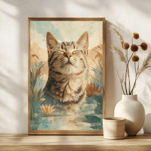 May include: A framed art print featuring a tabby cat with closed eyes, set against a serene landscape of water lilies and tall grasses. The artwork has a vintage, painterly style with soft blues, greens, and browns.