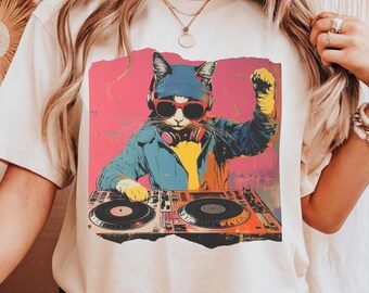 May include: White t-shirt with a colorful graphic of a cat wearing sunglasses and headphones, DJing on a turntable.