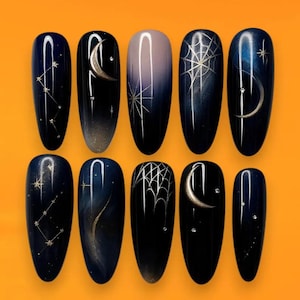 Könnte beinhalten: Ein Set aus zehn künstlichen Nägeln mit einem dunkelblauen und schwarzen Farbverlauf. Jeder Nagel zeigt einzigartige himmlische und Halloween-Motive, darunter Sternbilder, Monde, Spinnennetze und Sterne. Die Nägel sind oval und vor einem orangefarbenen Hintergrund angeordnet.