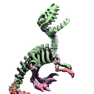 Puede incluir: Un juguete de esqueleto de dinosaurio impreso en 3D de color verde y morado. El dinosaurio está en posición de pie con la boca abierta.
