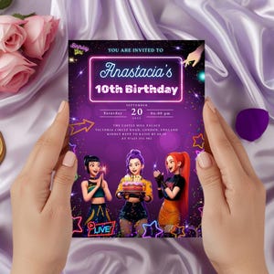 Op de afbeelding: Een paarse verjaardagsuitnodiging met de tekst "Anastacia's 10th Birthday" in een neon-stijl lettertype. De uitnodiging bevat illustraties van drie meisjes en evenementdetails. De uitnodiging wordt door twee handen vastgehouden, met een pen en bloemen op de achtergrond.