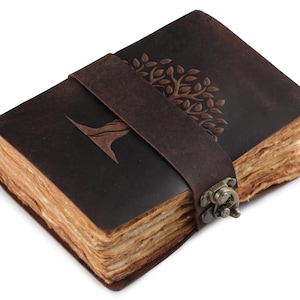 May include: A brown leather journal with a tree design embossed on the cover. The journal has a clasp closure and is made of aged paper.