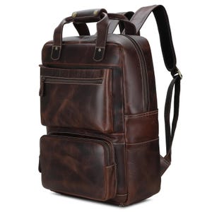 May include: A brown leather backpack with multiple pockets and a top handle. The backpack has a distressed look and is made of high-quality leather.