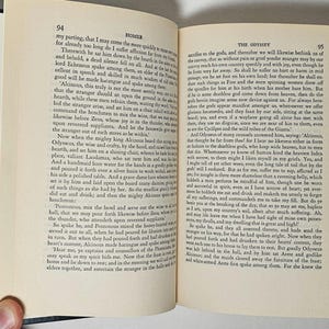 May include: Open book with text from Homer's Odyssey on cream-colored pages. The book is open to pages 94 and 95, with text in black font. The book has a black cover and is held by a hand.