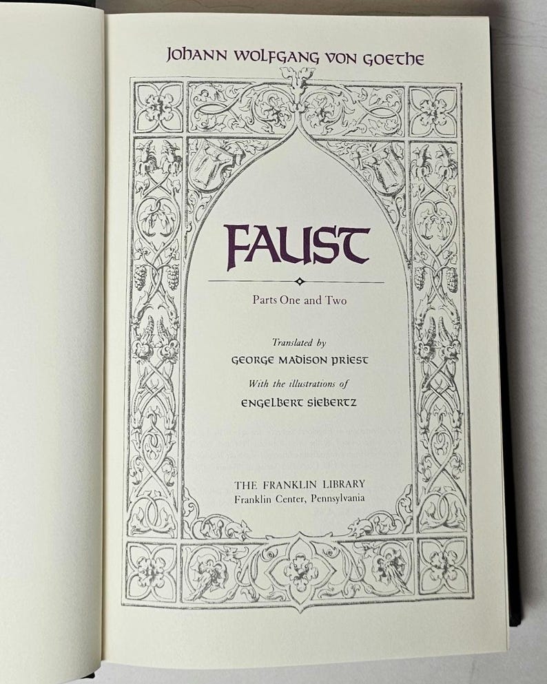 May include: Open book with the title page of "Faust" by Johann Wolfgang von Goethe. The title is in a decorative arch, with the text "Parts One and Two" below. The book is from The Franklin Library.